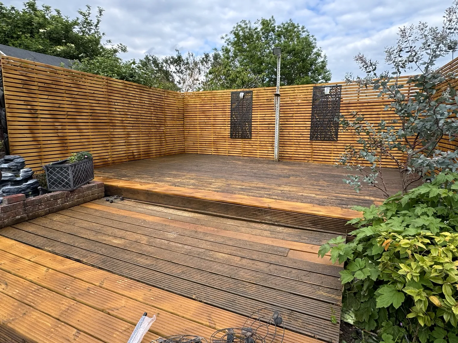Restored timber decking with modern slatted privacy fencing